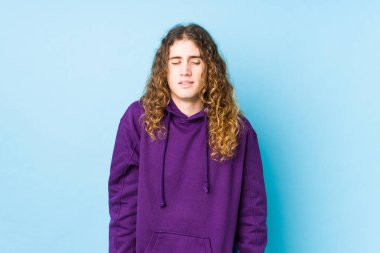 Uzun saçlı adam yalnız gülüyor ve gözlerini kapatıyor, rahatlamış ve mutlu hissediyor..