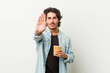 Genç havalı adam elini uzatıp kahve içiyor dur işareti gösteriyor, bu da seni engelliyor..