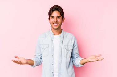 Pembe arka planda poz veren beyaz bir genç hoş bir yüz ifadesi sergiliyor..