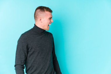 Mavi arka planda beyaz bir adam fotokopi odasına doğru bağırıyor.