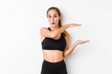 Beyaz arka planda poz veren beyaz tenli kadın elleri arasında bir fotokopi alanı tutarken şok oldu ve hayrete düştü..