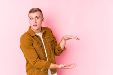 Kafkasyalı genç adam şok olmuş ve hayrete düşmüş. Ellerinin arasında bir kopya alanı tutuyor..