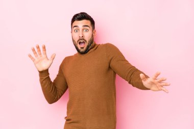 Pembe arka planda genç beyaz bir adam yakın bir tehlike nedeniyle izole edildi.