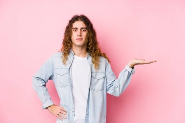 Uzun saçlı adam avuçta fotokopi alanı gösteriyor ve belinde bir el daha tutuyor..