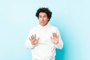 Mavi arka planda genç bir sporcu, tiksinti gösteren birini reddediyor..