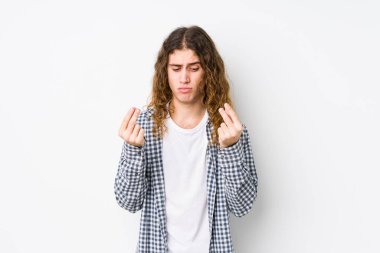 Genç, uzun saçlı adam yalnız poz veriyor. Parası olmadığını gösteriyor..