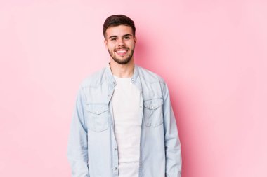 Beyaz arka planda poz veren beyaz tenli genç iş adamı mutlu, güler yüzlü ve neşeli..