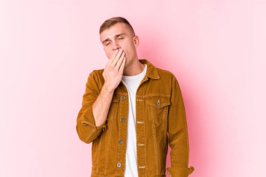 Kafkasyalı genç adam kendini izole etmiş esniyor. Ağzı eliyle kapatan yorgun bir hareket sergiliyor..