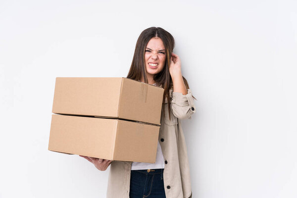 Young caucasian woman moving to a new home covering ears with hands.