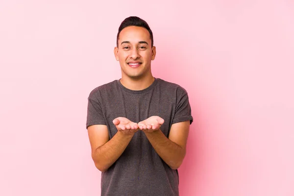 Yooung Latino Homem Posando Fundo Rosa Segurando Algo Com Palmas — Fotografia de Stock