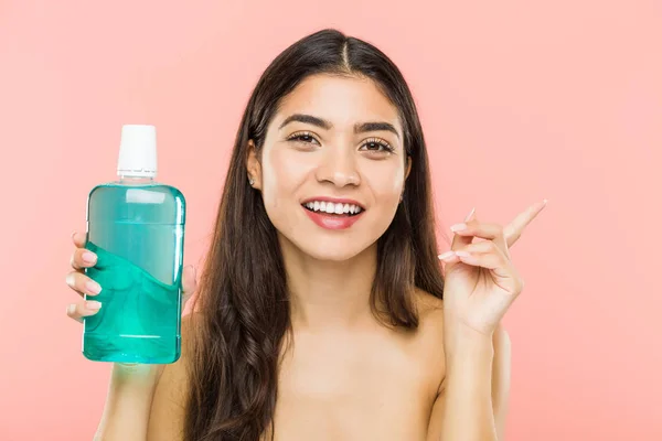 Young Indian Woman Holding Mouthwash Bottle Smiling Cheerfully Pointing Forefinger — 스톡 사진