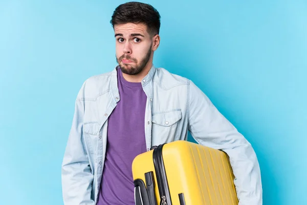 Young Caucasian Traveler Man Holding Suitcase Isolated Shrugs Shoulders Open — Stock Photo, Image