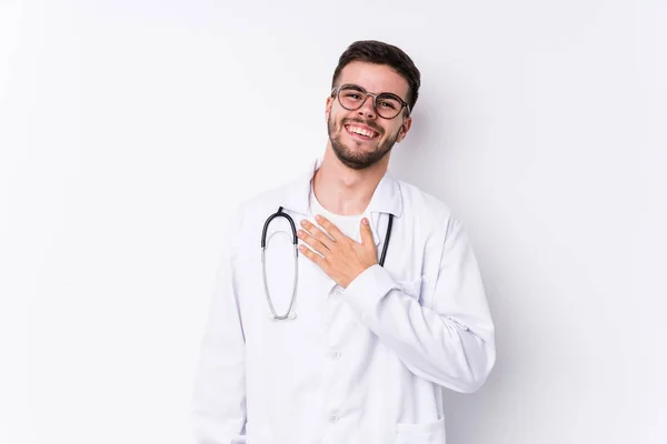 Jovem Homem Médico Caucasiano Isolado Voz Alta Mantendo Mão Peito — Fotografia de Stock