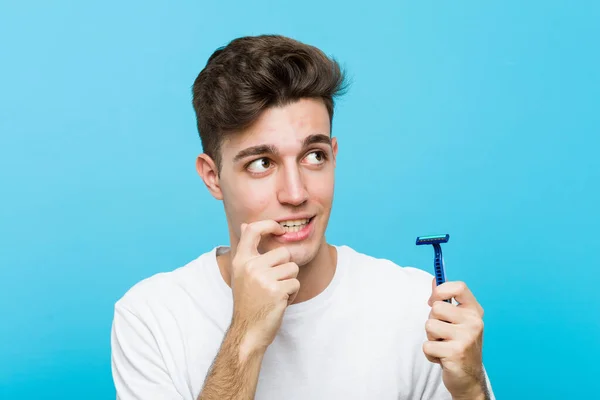 Joven Hombre Caucásico Sosteniendo Una Hoja Afeitar Relajado Pensando Algo — Foto de Stock