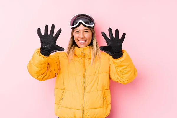 Young Caucasian Woman Wearing Ski Clothes Pink Background Showing Number — 스톡 사진