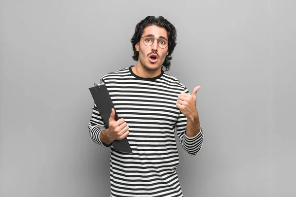 Joven Empleado Sosteniendo Inventario Apuntando Hacia Lado — Foto de Stock