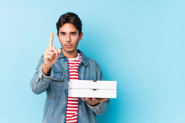 Young Caucasian Man Holding Pizzas Isolated Showing Number One Finger — 스톡 사진