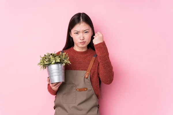 Fiatal Kínai Kertész Kezében Egy Növény Elszigetelt Bemutató Ököllel Kamera — Stock Fotó