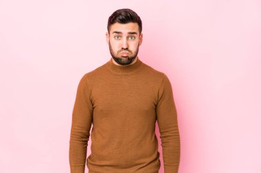 Pembe arka planı olan beyaz bir genç yanakları soyutlamış, yorgun bir ifadeye sahip. Yüz ifadesi kavramı.