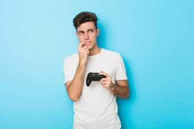 Oyun kontrolörüyle video oyunu oynayan genç beyaz adam bir şeyin fotokopi alanına baktığını düşünerek rahatladı..