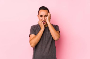 Pembe arka planda poz veren, mızmızlanan ve ağlayan seni gidi Latin adam..