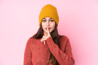 Yün şapkalı genç beyaz kadın sır saklıyor ya da sessizlik istiyor..