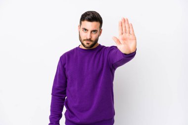 Beyaz arka planı olan beyaz tenli genç bir adam elini uzatmış, dur işareti göstererek seni engelliyor..