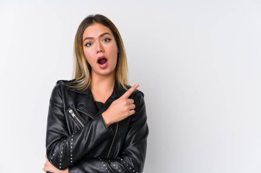 Siyah deri ceketli beyaz bir kadın yan tarafı işaret ediyor.