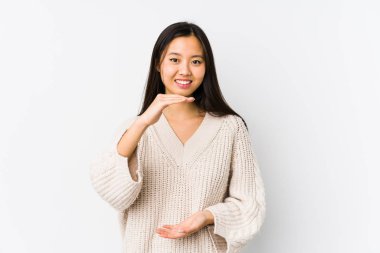 Genç Çinli kadın iki eliyle bir şey tutuyor, ürün sunumu..