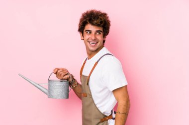 Kafkasyalı genç bahçıvan yalnız. Gülümsüyor, neşeli ve keyifli görünüyor..