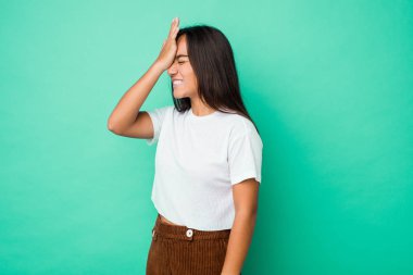 Genç melez Hintli kadın bir şeyi unutuyor. Alnına avuç içi ve kapalı gözlerle vuruyor..