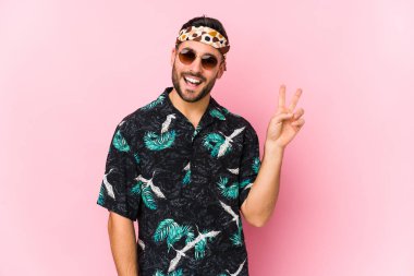 Genç hippi, neşeli ve tasasız bir şekilde parmaklarıyla barış sembolü gösterdi..