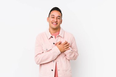 Yalnız poz veren genç latin adam, avuçlarını göğsüne bastıran dostça bir ifadeye sahiptir. Aşk konsepti.