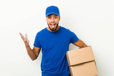 Genç Güney Asyalı teslimatçı hoş bir sürpriz alıyor, heyecanlı ve el kaldırıyor..