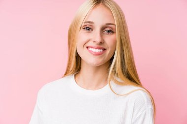 Pembe arka planda soyutlanmış genç sarışın kadın yüzü.
