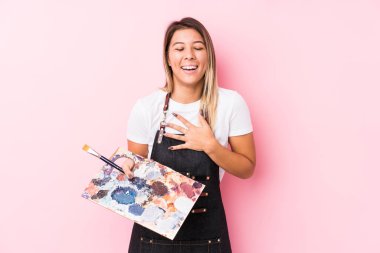 Kafkasyalı genç bir kadın palet tutuyor, kahkahalar atıyor, elini göğsüne koyuyor..