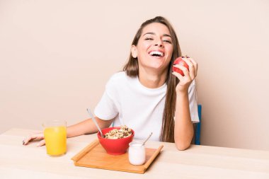 Genç beyaz kadın kahvaltı yapıyor.