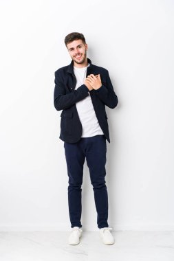 Tam gövdeli, beyaz tenli bir adam dost canlısı bir ifadeye sahip, avuçlarını göğsüne bastırıyor. Aşk konsepti.