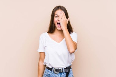 Kafkasyalı genç kadın yalnız poz veriyor. Yüzünün yarısını palmiyeyle kaplayarak eğleniyor..