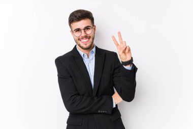 Beyaz arka planda poz veren beyaz tenli genç beyaz iş adamı iki numarayı parmaklarıyla gösterdi..