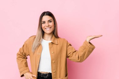 Kafkasyalı genç bir kadın avucunun içinde fotokopi odası gösteriyor ve belinde bir el daha tutuyor..