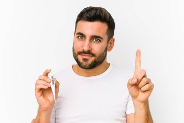 Termometreyi tutan genç beyaz bir adam genç beyaz bir adamın parmağıyla bir numarayı tuttuğunu gösteriyor..