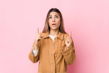 Kafkasyalı genç bir kadın, ağzı açık, üst tarafı işaret ederek izole edilmiş..