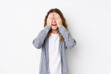 Genç, uzun saçlı, yalnız poz veren adam elleriyle gözlerini kapatıyor. Gülümsüyor ve bir sürpriz bekliyor..