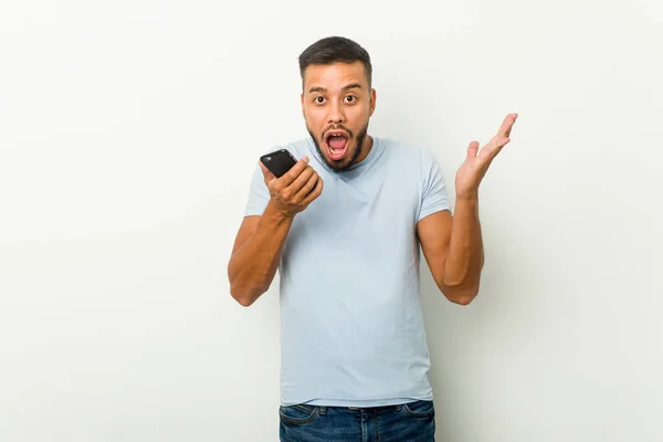 Young Mixed Race Asian Man Holding Phone Celebrating Victory Success — Stock Photo, Image