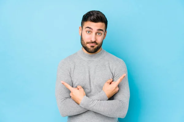 Young Caucasian Man Blue Background Isolated Points Sideways Trying Choose — Stockfoto