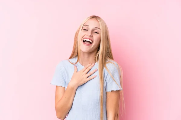 Ung Blond Kvinna Rosa Bakgrund Skrattar Högt Hålla Handen Bröstet — Stockfoto