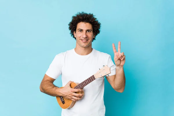 Young Caucasian Curly Man Playing Ukelele Showing Victory Sign Smiling — 스톡 사진