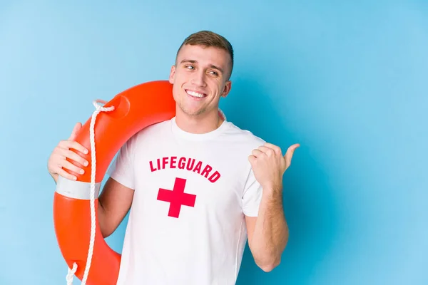 Young Lifeguard Man Holding Rescue Float Points Thumb Finger Away — 스톡 사진