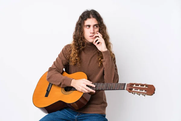 Joven Hombre Caucásico Tocando Guitarra Aislado Relajado Pensando Algo Mirando —  Fotos de Stock